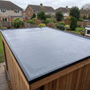 Garden room flat roof covered by one seamless sheet of 1.2mm slate grey EPDM rubber membrane with black edge trims, wet after rain