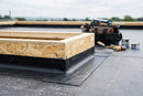OSB insulated skylight upstand kerb installed on a flat roof with EPDM membrane dressed around the base