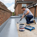 Fire-rated GRP topcoat being applied to a flat roof near a boundary wall, RUBBER ROOF UK branded tin