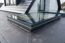 Closed electric opening rooflight with slim anthracite frame on an EPDM flat roof