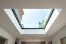 Interior view looking up through a walk-on glass rooflight showing daylight and thick laminated glass edge