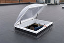 Person climbing out through an open flat roof access hatch onto an EPDM rubber roof