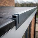 Anthracite grey uPVC roof edge trim installed on a flat roof EPDM membrane edge