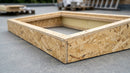 Close-up of OSB insulated skylight upstand corner construction showing timber panel and insulated core
