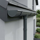 Anthracite grey half round aluminium gutter with downpipe on a modern rendered house
