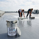 Roofers laminating a large commercial GRP flat roof with RUBBER ROOF UK branded fire-rated resin