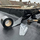 Uncured EPDM flashing tape being dressed around an external corner upstand on an EPDM flat roof