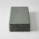 Stack of natural grey-green roofing slates with pre-holed fixing holes