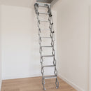 Compact aluminium concertina loft ladder with telescopic handrail extended from a small ceiling opening on a UK landing