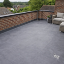 Completed 1.5mm EPDM rubber flat roof terrace on brick house with garden furniture - premium flat roofing UK