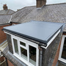 Finished flat-top dormer with a one-piece slate-grey EPDM rubber roof, black gutter drip trim on the front edge and the membrane dressed up under the slates behind - dormer rubber roof kit