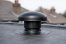 Black mushroom-style breather vent installed and sealed on an EPDM rubber flat roof
