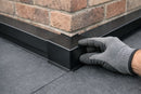 Black EPDM drip trim internal corner fitted at an inside corner of an L-shaped rubber flat roof