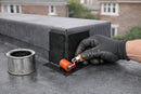 EPDM external corner patch being rolled onto the outside corner of a membrane upstand on a rubber flat roof