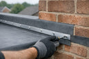 Aluminium termination bar clamping EPDM rubber membrane against a brick parapet wall upstand