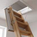 Close-up of the folded timber loft ladder sections and thick insulated fire-rated hatch door seen from below
