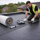 Roofer in safety vest unrolling fleece-reinforced EPDM membrane – the material used in this commercial gutter lining system