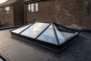Jet black aluminium roof lantern on a black EPDM rubber flat roof at dusk
