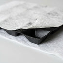 Close-up of a green roof drainage board showing the dimpled core and filter fleece layer