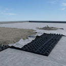 Black HDPE cuspated green roof drainage board being laid on a flat roof deck before the growing medium
