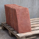 Stack of handmade clay plain roof tiles in the Red Antique colourway