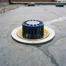 Large-capacity anti-vortex aluminium roof drain outlet installed flush in a flat roof membrane with rainwater draining through the dome grate