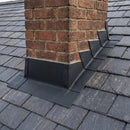 Black lead-free flashing dressed around a brick chimney stack on a UK pitched slate roof