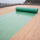 Translucent green polythene vapour control layer unrolled across a flat roof deck before insulation