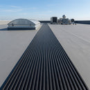 Black PVC walkway matting laid across a flat commercial roof forming an access path