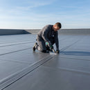 PVC single-ply roofing membrane being hot-air welded on a flat commercial roof