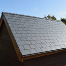 Dark grey recycled rubber synthetic slate tiles laid on a small outbuilding roof