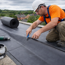 Roofer cutting 1.2mm EPDM rubber membrane to size on flat roof with knife - rubber roofing membrane UK