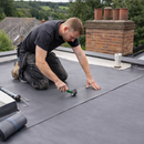 Roofer rolling 1.5mm EPDM rubber membrane flat onto commercial roof with pressure roller - heavy duty roofing UK
