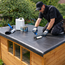 Roofer rolling EPDM adhesive on garden shed flat roof with roofing tools - shed rubber roof kit UK