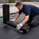 Roofer unrolling 2.5mm self-adhesive EPDM membrane roll on flat roof - partial bond 3-in-1 waterproofing system UK