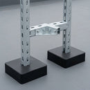 Close-up of a galvanised slotted strut channel rooftop support frame standing on square black rubber feet