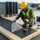 Roofer peeling release film off 2.5mm self-adhesive EPDM partial bond membrane on flat roof - self-adhesive EPDM UK