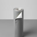 Close-up of a rolled self-adhesive underlay membrane end showing the release liner