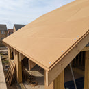 Wood fibre sarking boards fitted across roof rafters on a UK timber-frame roof under construction